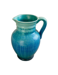 Blue ceramic pitcher on a wooden surface