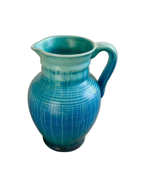 Blue ceramic pitcher on a wooden surface
