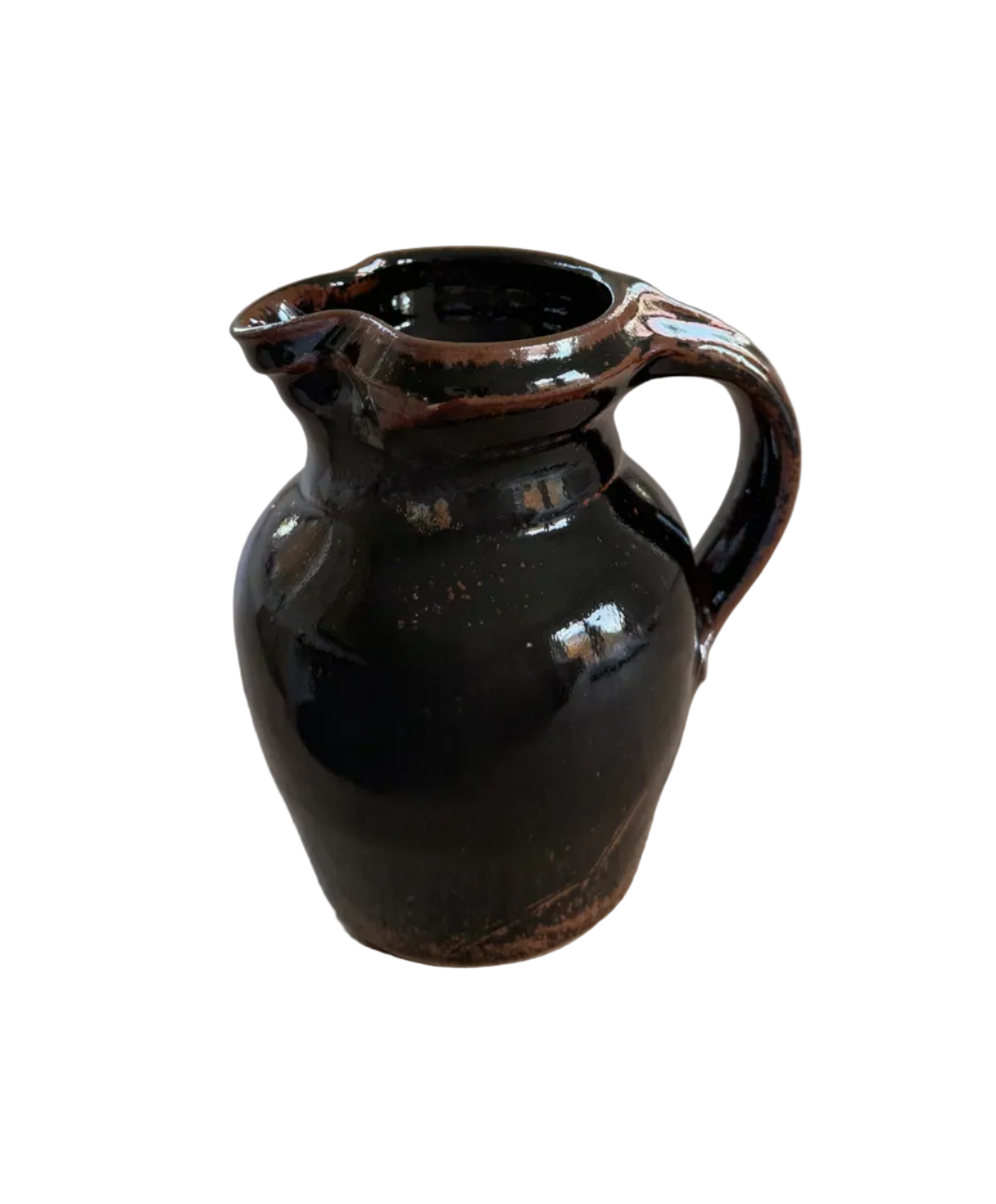 Black ceramic pitcher on a wooden surface